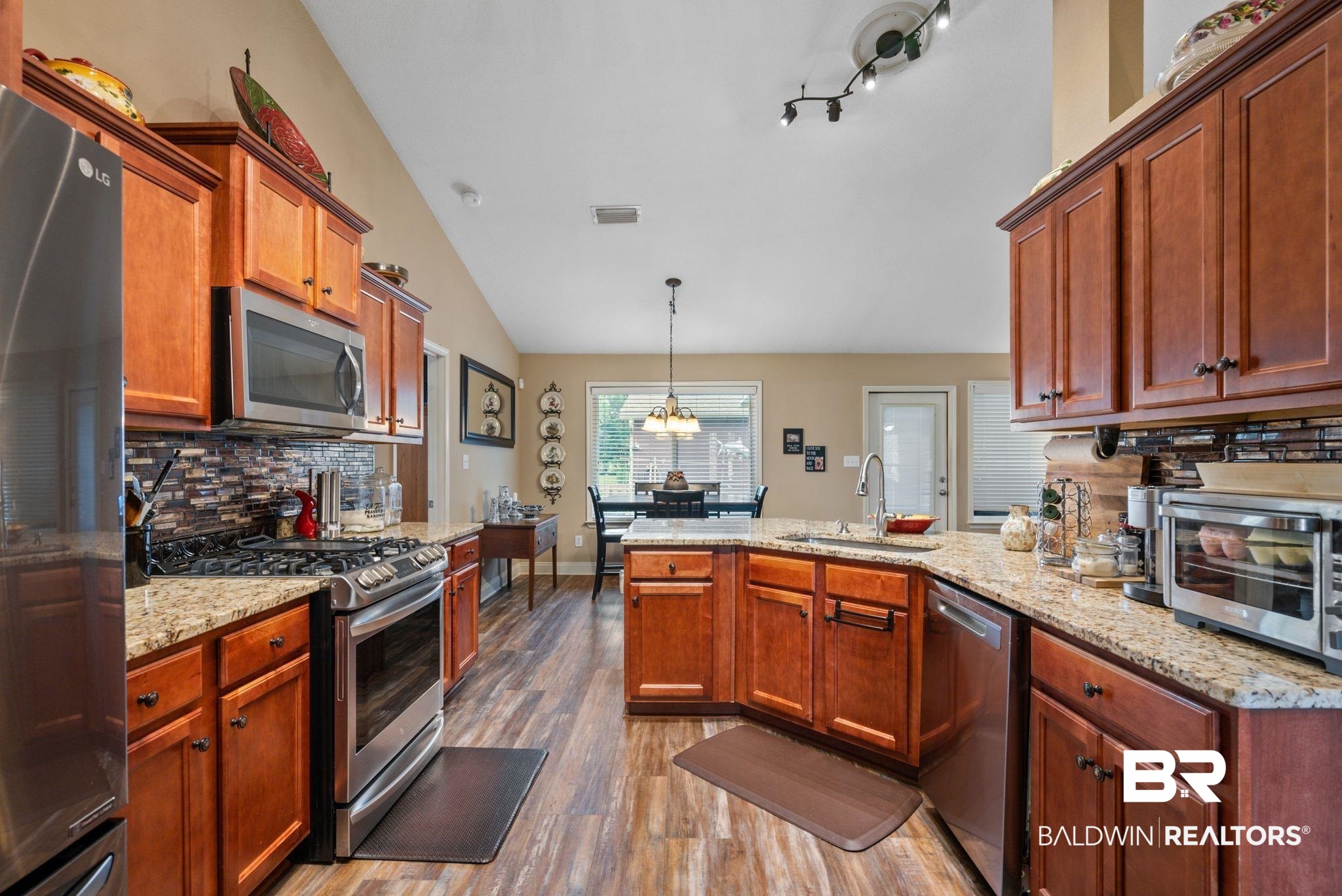 562 Vestige Mews Foley, AL 36535 - Photo 17 of 54 Kitchen featuring wood-finish flooring, granite countertops, and stainless steel appliances