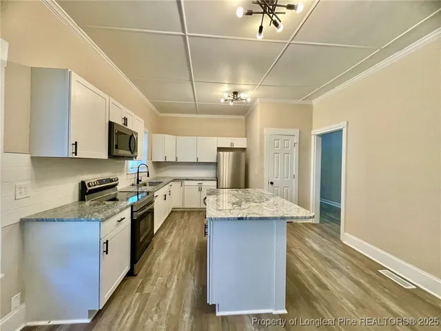a kitchen with stainless steel appliances granite countertop a sink stove and refrigerator