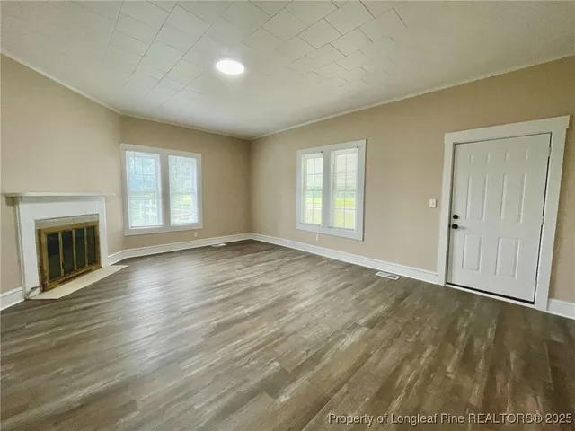 an empty room with wooden floor and a window