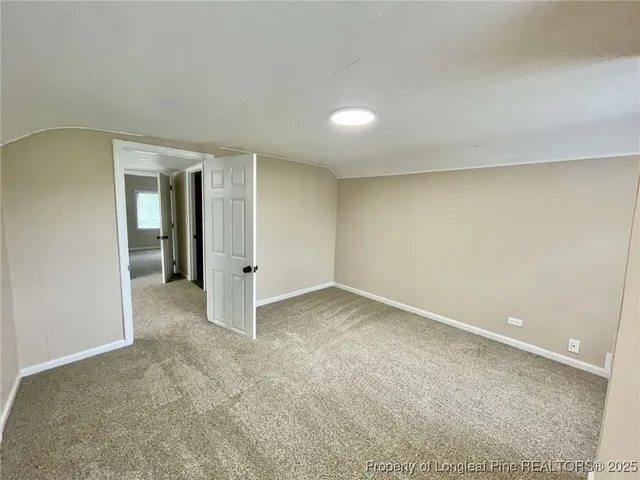 an empty room with an entryway and closet area