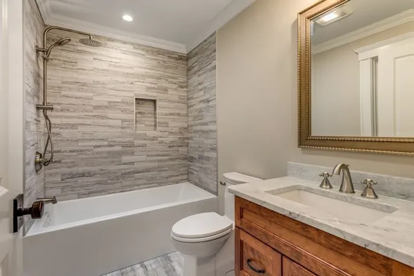 a bathroom with a granite countertop sink toilet and shower