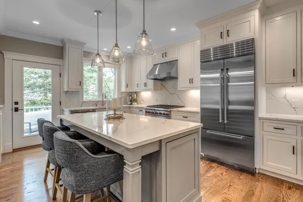 a kitchen with granite countertop a sink a center island stainless steel appliances and cabinets
