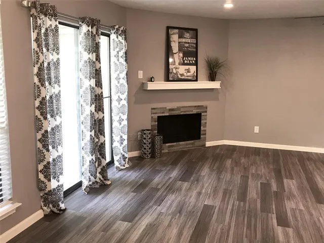 a view of a livingroom with wooden floor and a fireplace