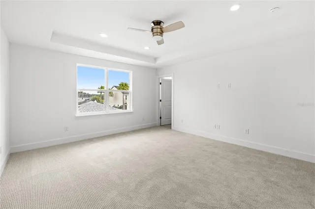 an empty room with windows and ceiling fan