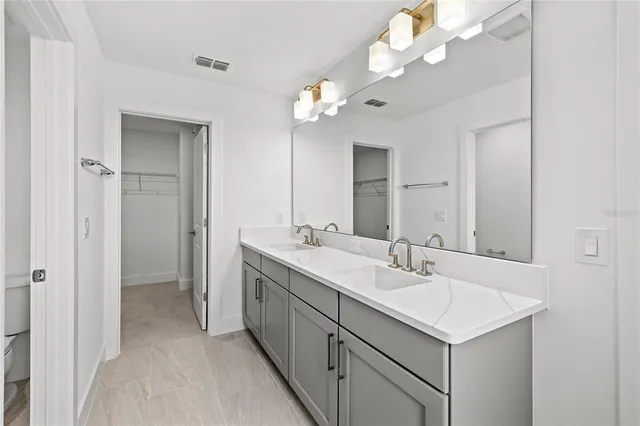 a bathroom with a sink a light fixture and a mirror