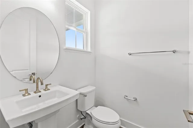 a bathroom with a toilet a sink and mirror