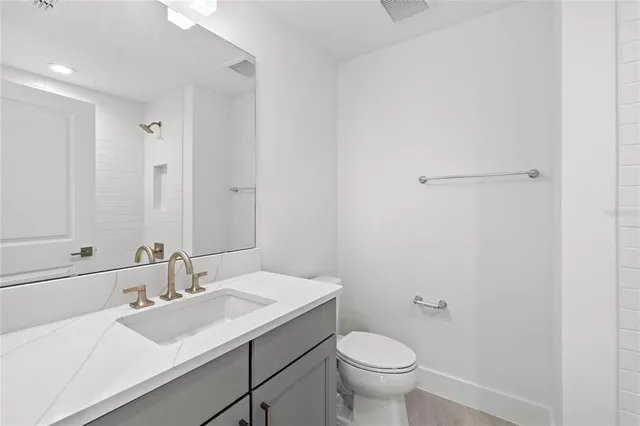 a bathroom with a sink toilet and a mirror