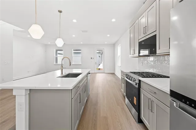 a kitchen with a sink and stainless steel appliances