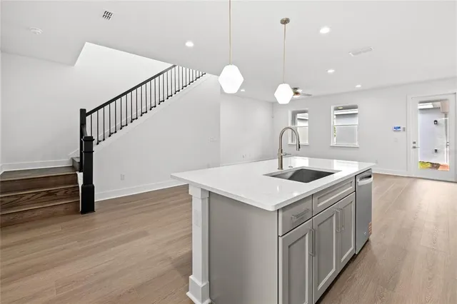 a kitchen that has a sink a microwave oven a stove and wooden floor