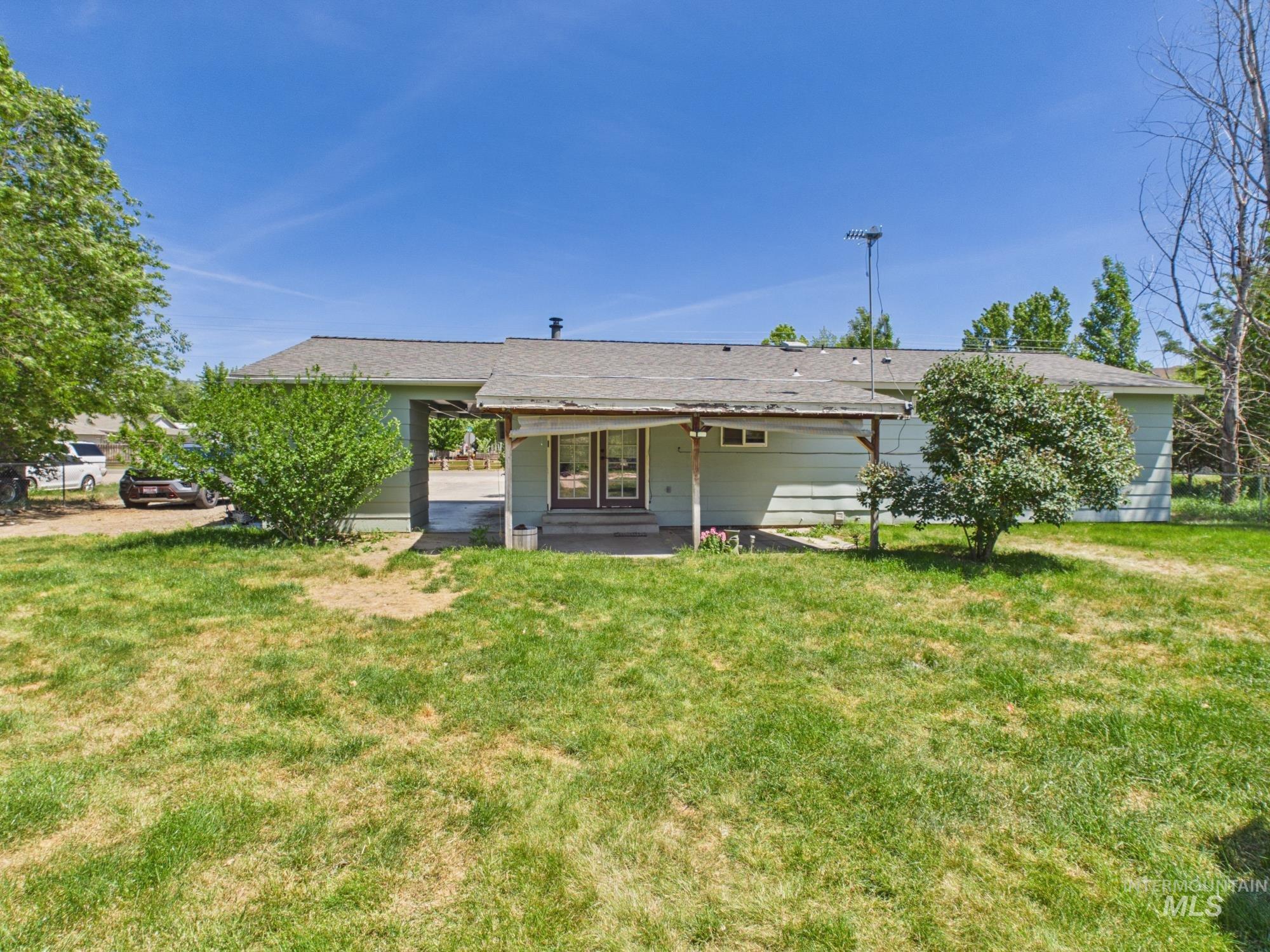 1527 North Plaza Road Emmett, ID 83617 - Photo 29 of 33 Rear exterior featuring a covered patio, double glass doors, light green siding, and a gabled roof