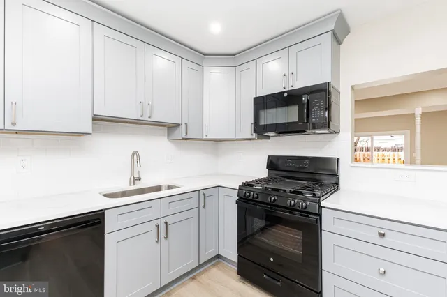 a kitchen with granite countertop white cabinets and appliances