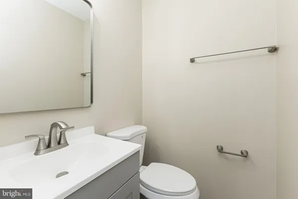 a bathroom with a sink a toilet and mirror