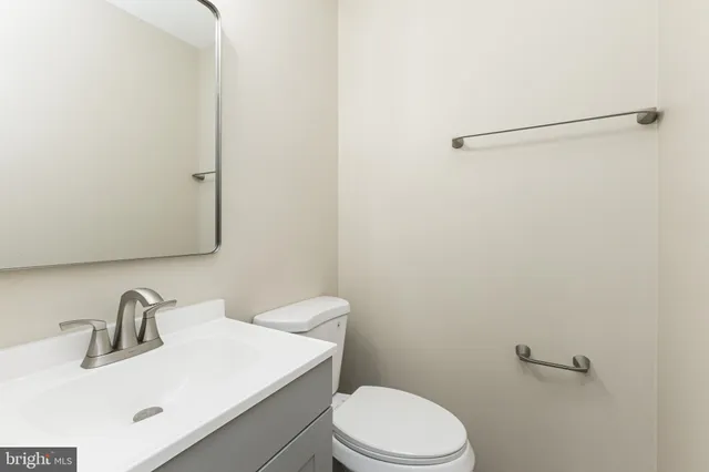 a bathroom with a sink a toilet and mirror