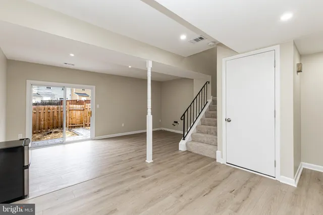 a view of an entryway with wooden floor stairs and a living room