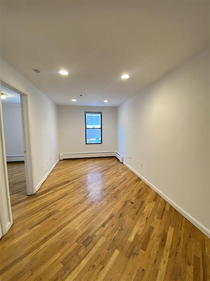 409 1st Street, Unit A Hoboken, NJ 07030 - Photo 1 of 10 an empty room with wooden floor and windows