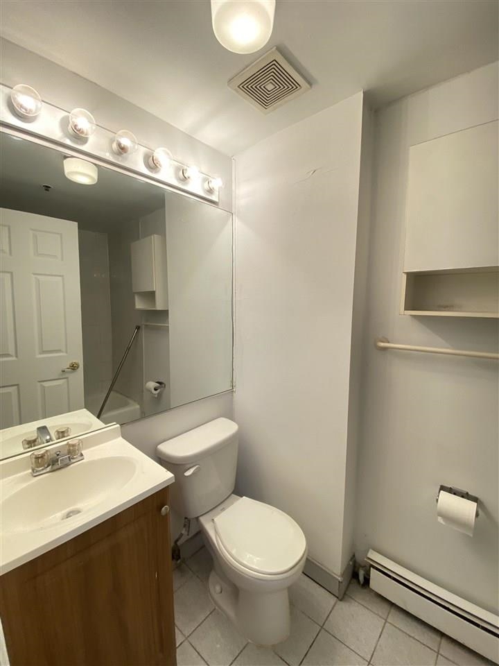409 1st Street, Unit A Hoboken, NJ 07030 - Photo 6 of 10 a bathroom with a toilet sink and mirror
