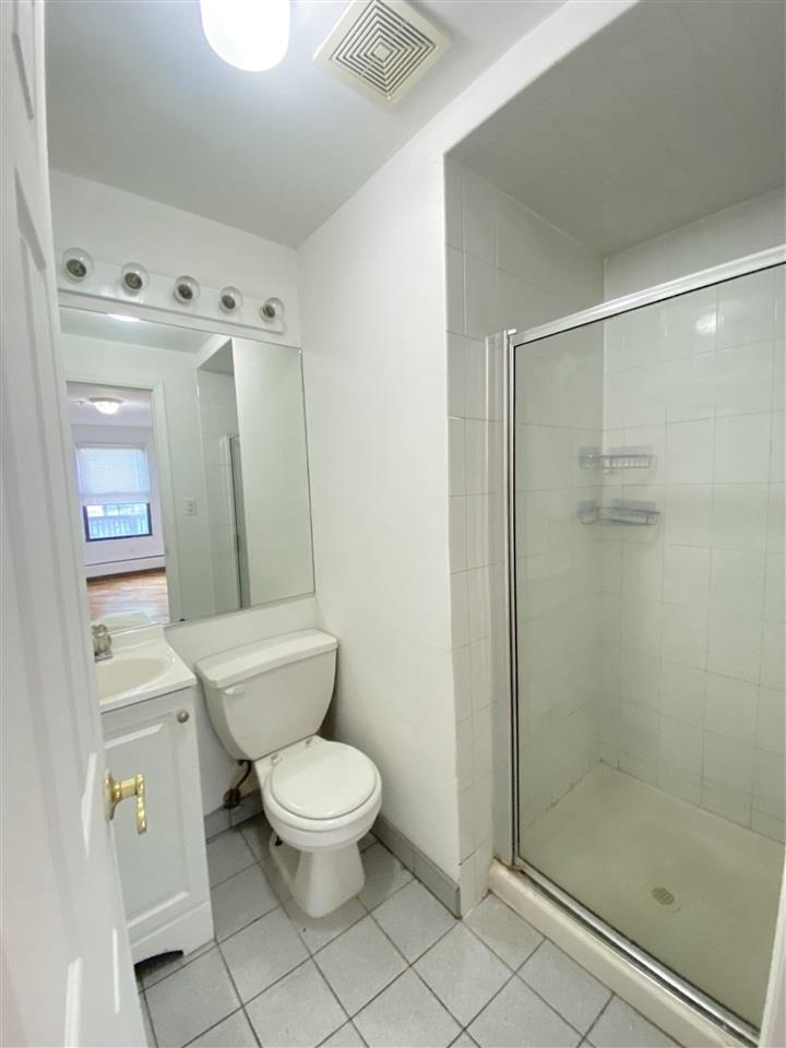 409 1st Street, Unit A Hoboken, NJ 07030 - Photo 7 of 10 a white toilet sitting next to a bathroom sink