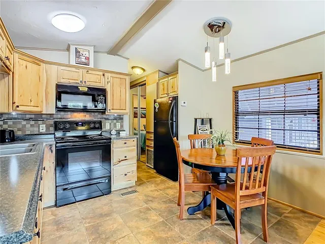 a kitchen with stainless steel appliances a stove a refrigerator and a dining table