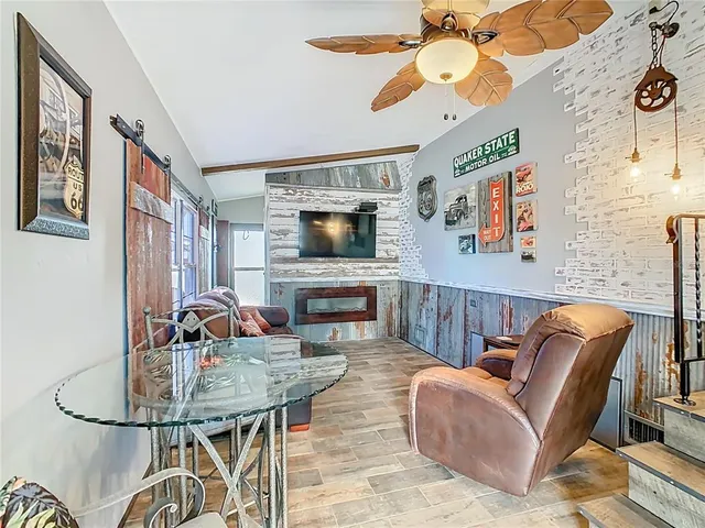 a living room with furniture a fireplace and a flat screen tv