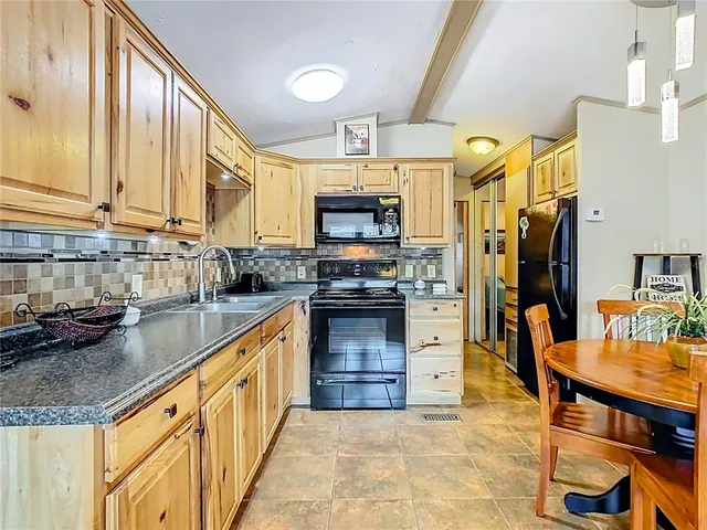 a kitchen with stainless steel appliances granite countertop a stove a sink and a refrigerator