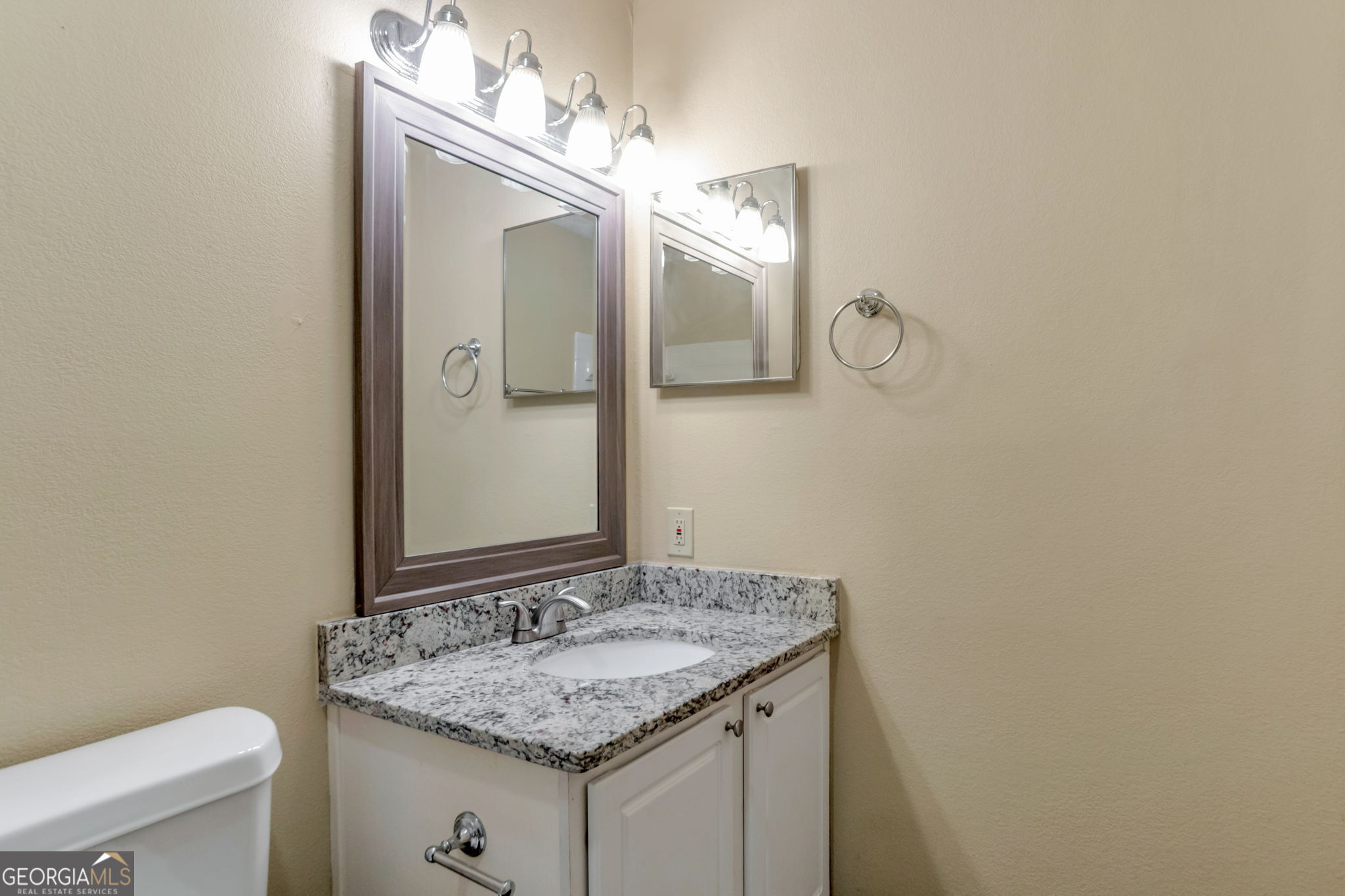 5155 Roswell Road, Unit 9 Atlanta, GA 30342 - Photo 13 of 20 a bathroom with a granite countertop sink and a mirror