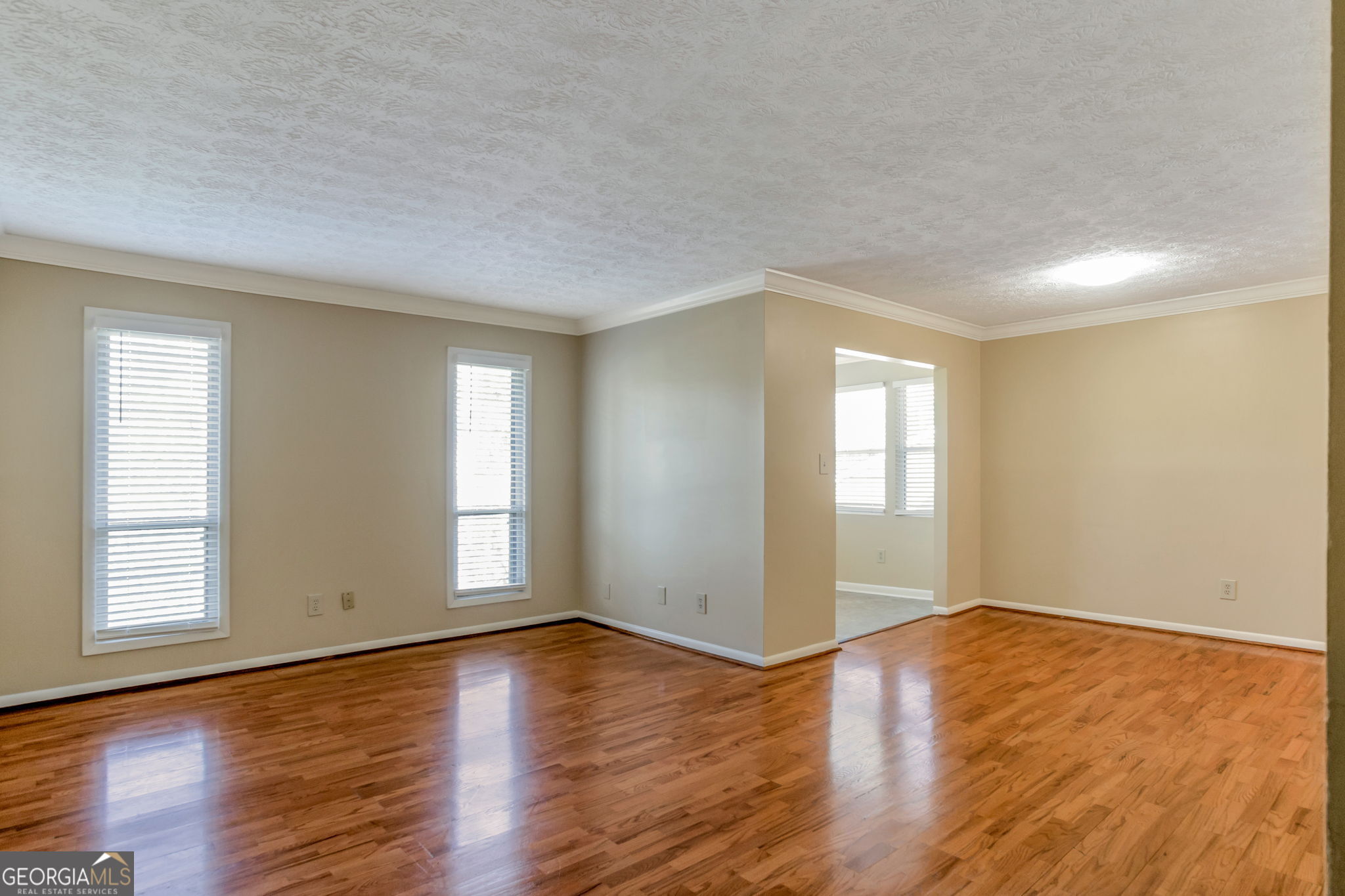 5155 Roswell Road, Unit 9 Atlanta, GA 30342 - Photo 3 of 20 an empty room with wooden floor and windows with curtains view