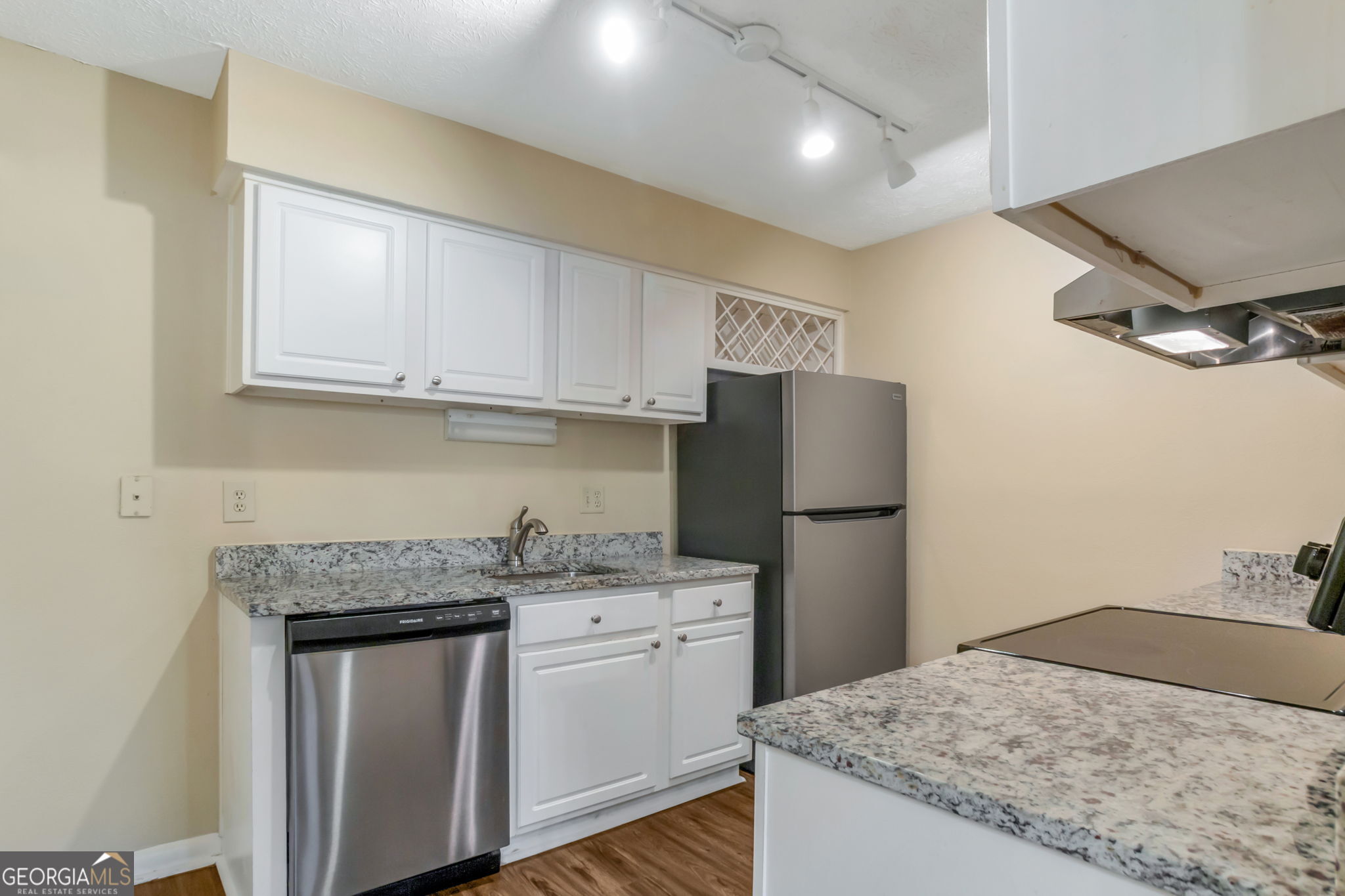5155 Roswell Road, Unit 9 Atlanta, GA 30342 - Photo 8 of 20 a kitchen with a sink a refrigerator and cabinets