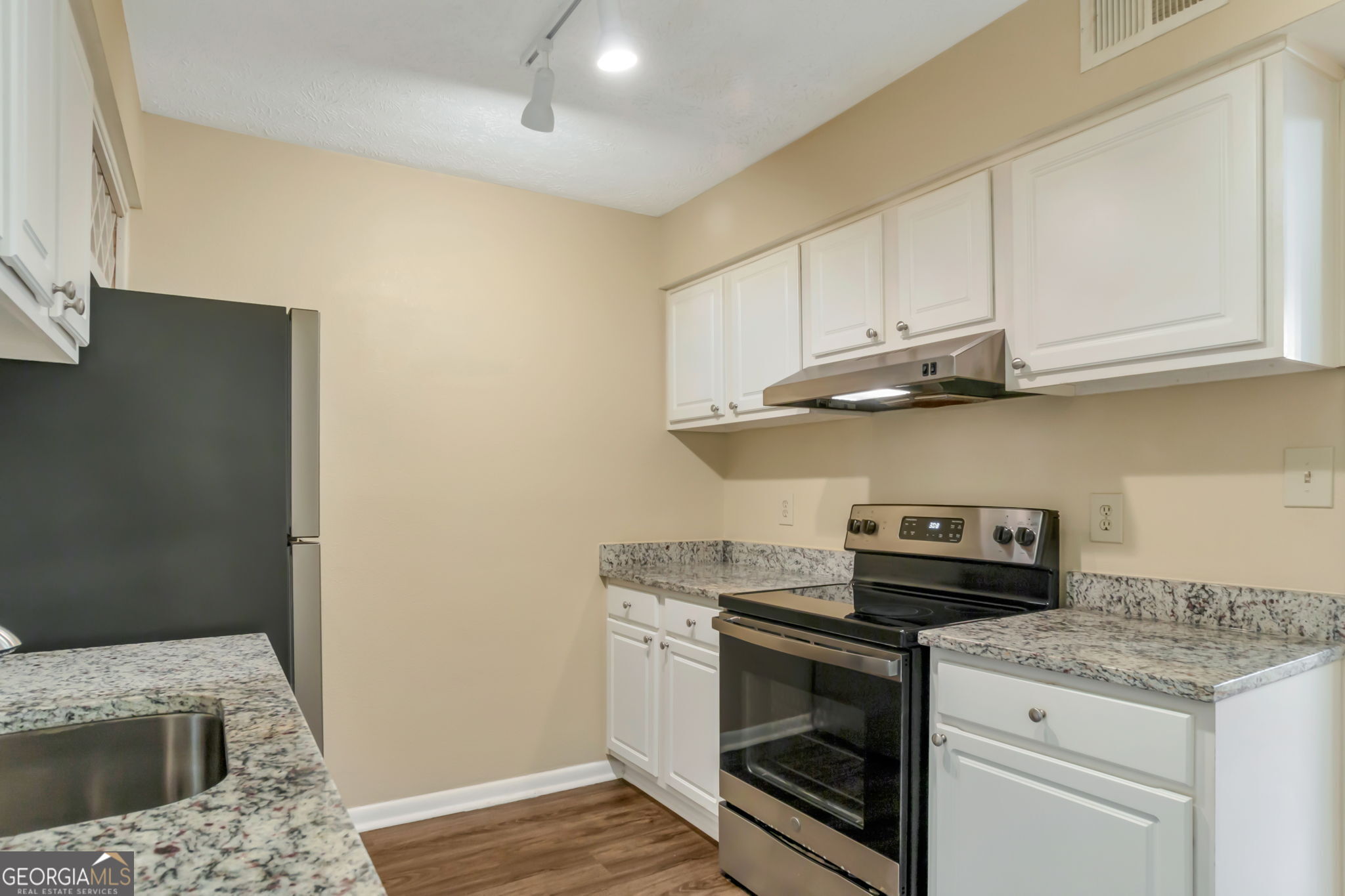 5155 Roswell Road, Unit 9 Atlanta, GA 30342 - Photo 9 of 20 a kitchen with granite countertop a sink a stove and cabinets