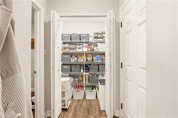 a view of a hallway with wooden floor and a window