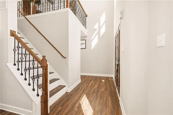 a view of staircase with wooden floor and white walls