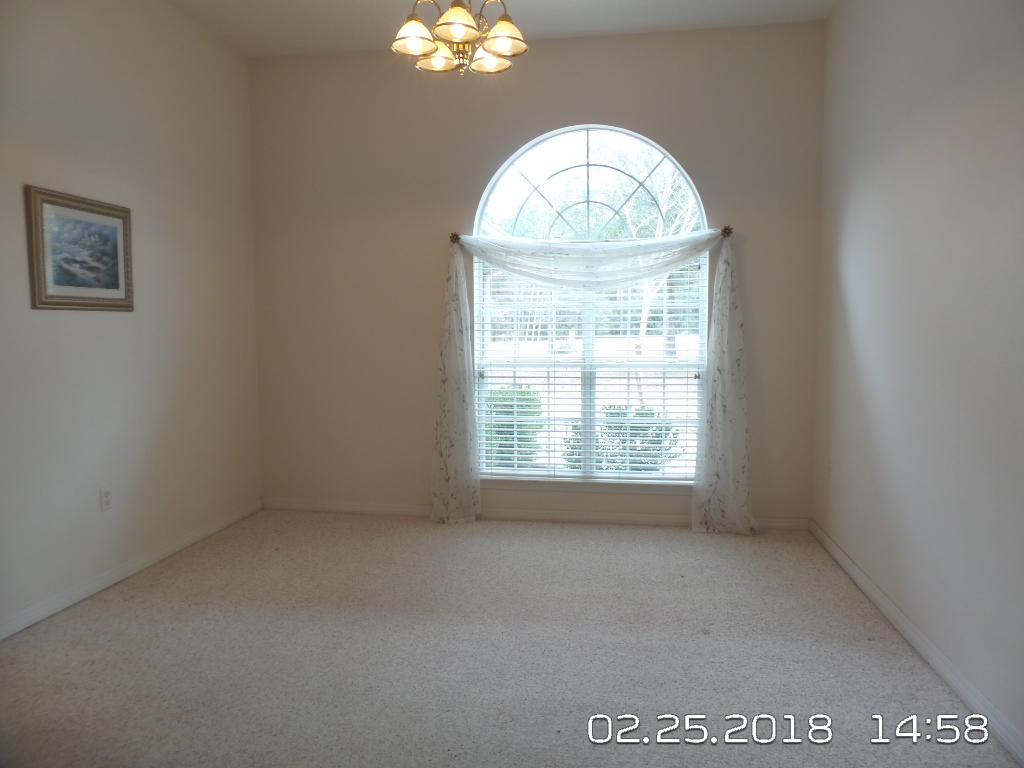 3807 Poverty Creek Road Crestview, FL 32539 - Photo 7 of 27 an empty room with a chandelier fan and windows