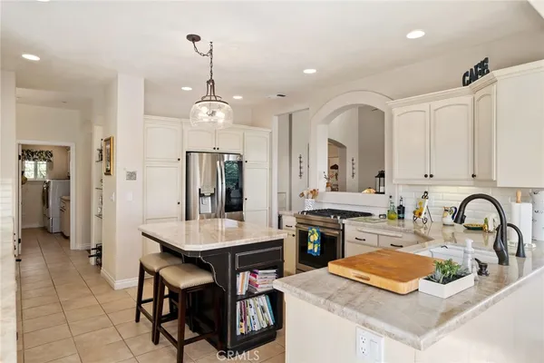 a kitchen with granite countertop a sink stainless steel appliances and dining table