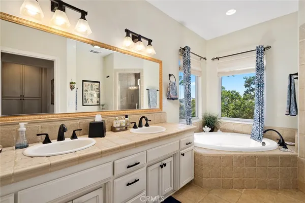 a bathroom with a granite countertop double vanity sink and mirror