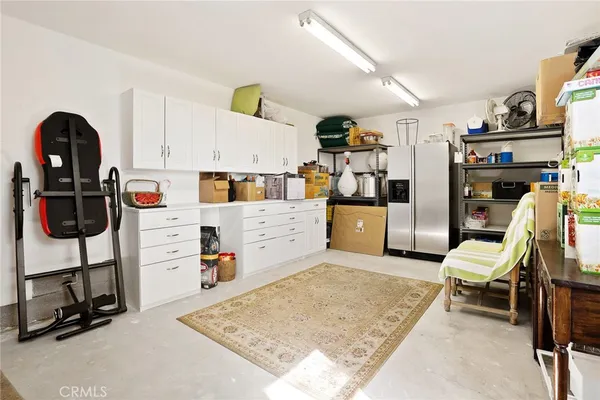 a room with lots of white furniture and a rug