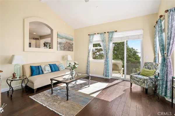 a living room with furniture and a large window with wooden floor