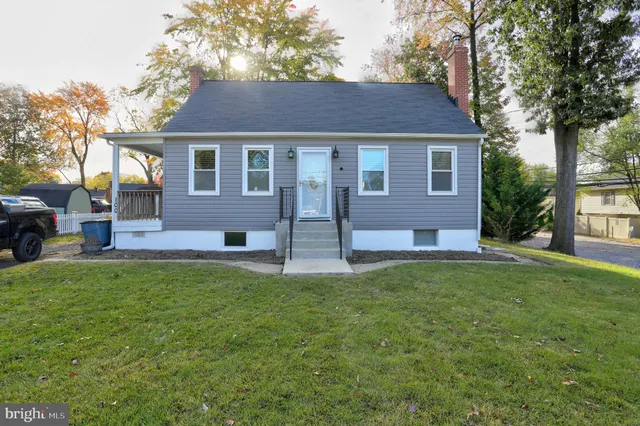a front view of a house with a yard and trees