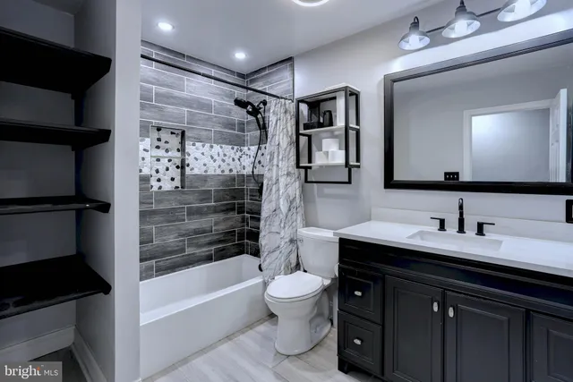 a bathroom with a double vanity sink toilet mirror and bathtub