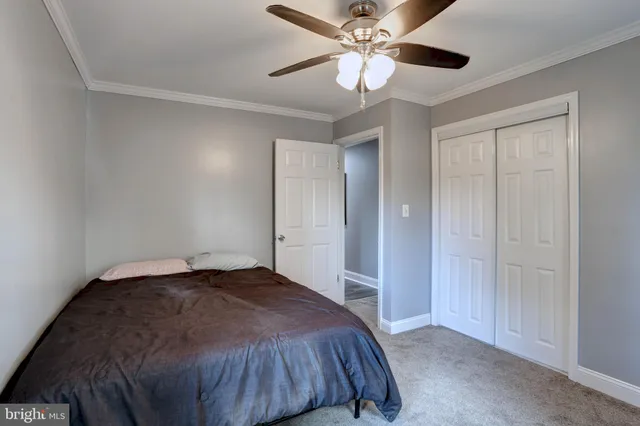 a bedroom with a bed and a ceiling fan