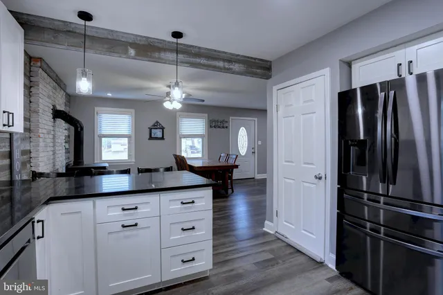 a kitchen with granite countertop a refrigerator and a sink