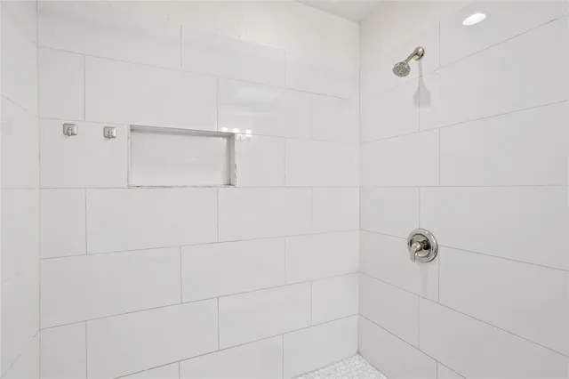 an empty room with wooden floor chandelier fan and windows