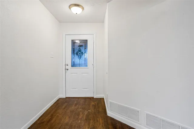 a view of a hallway with wooden floor