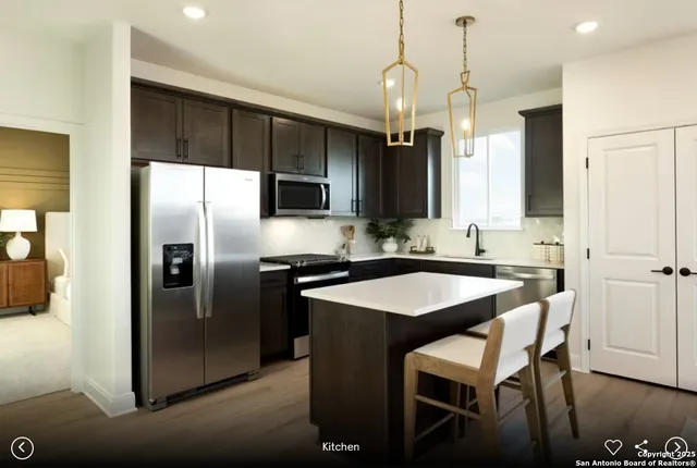 a kitchen with stainless steel appliances granite countertop a sink a stove a refrigerator and island