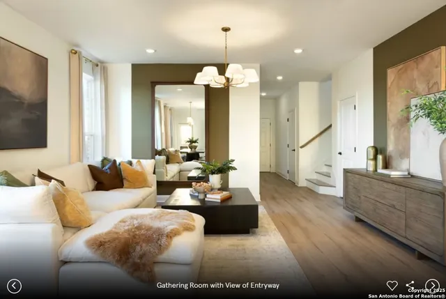 a living room with furniture chandelier and a flat screen tv
