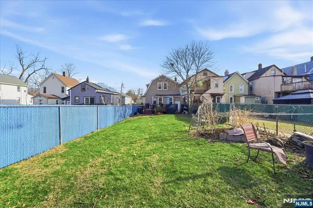 a view of a house with a big yard and large trees