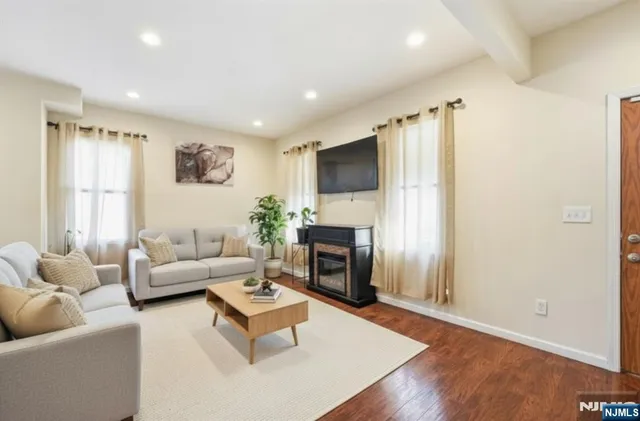 a living room with furniture a fireplace and a flat screen tv
