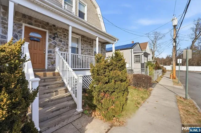 a view of a house with entrance stairs and a garden