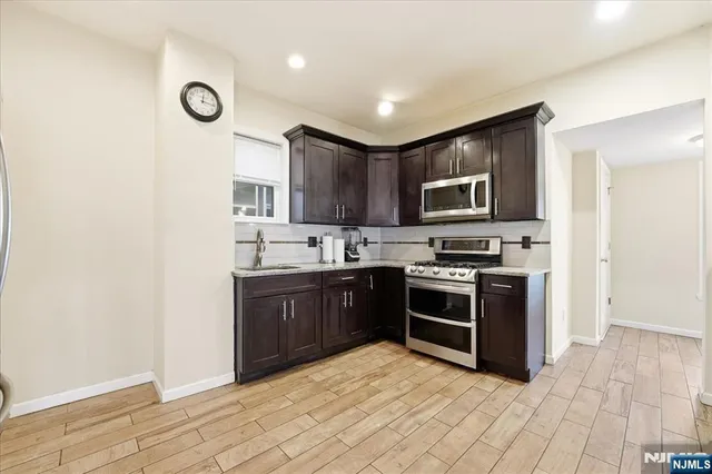 a large kitchen with stainless steel appliances granite countertop a stove and a sink