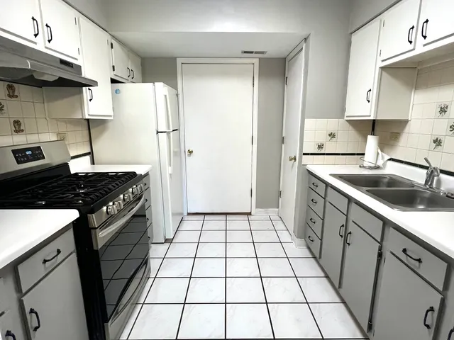 a kitchen with a stove a refrigerator and a sink