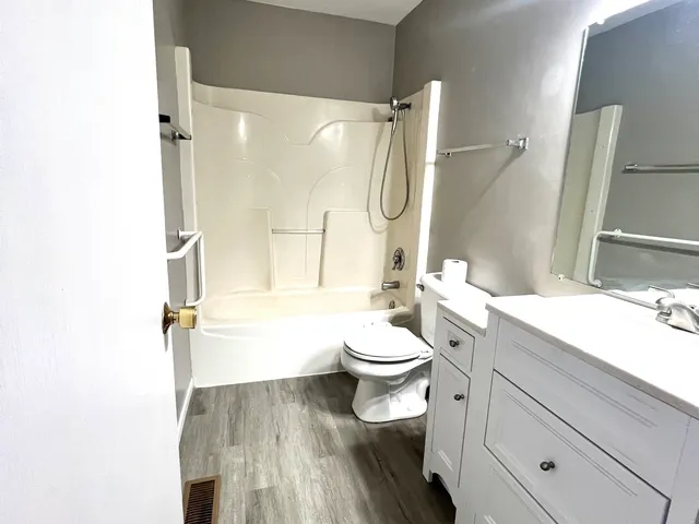 a bathroom with a granite countertop toilet sink and shower