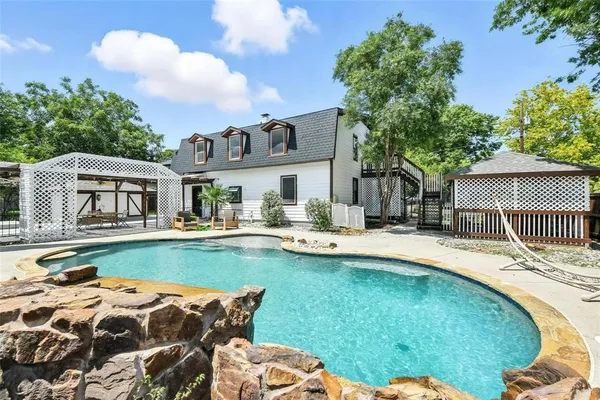 a view of a house with pool and chairs